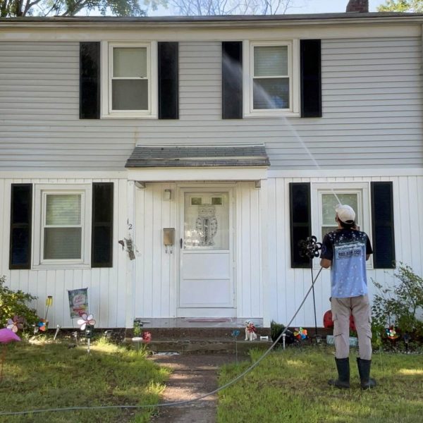 house washing Powerwash The PowerWashing Kings professiona washing siding of gray and white home