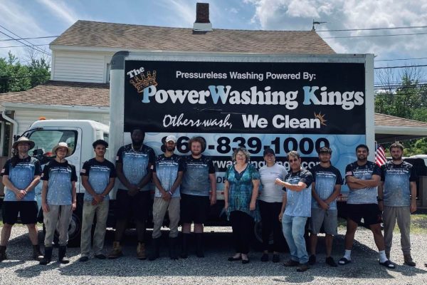 The Powerwashing Kings team standing in front of a pressure-washing truck